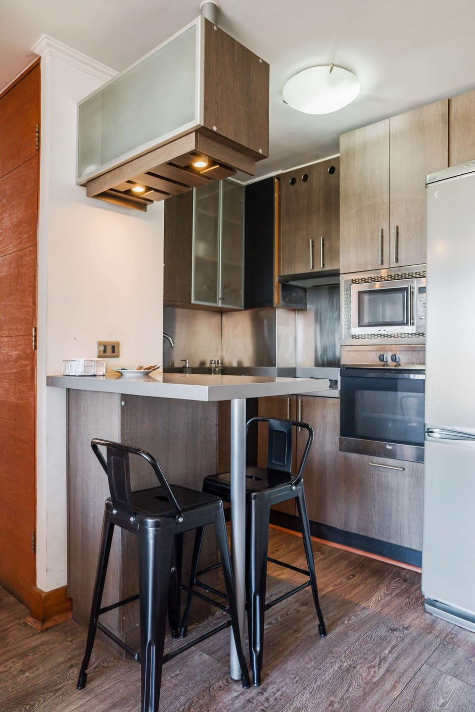 Cozy and modern kitchen with sleek appliances and a convenient breakfast bar, perfect for quick meals.