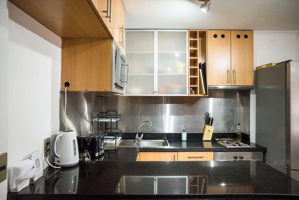 Modern kitchen with sleek appliances and ample storage, perfect for cooking at home.