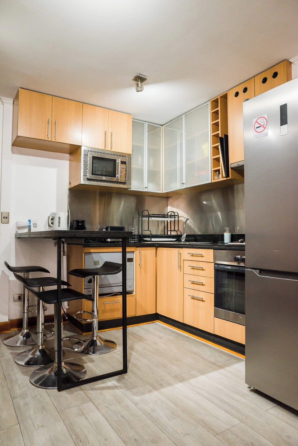 Modern kitchen with sleek appliances and a cozy breakfast bar, perfect for enjoying a quick meal.