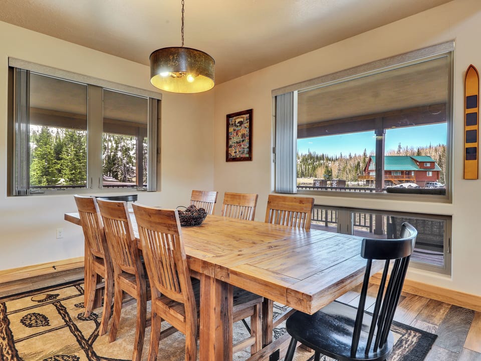 The dining room features a dining table with seating for 8, a chandelier, and a decorative rug, creating an inviting and elegant space