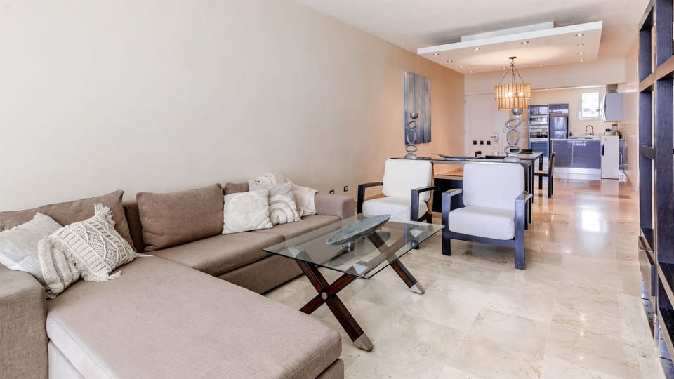Large and bright living room with open layout, comfortable sofas, dining area, and panoramic ocean views, ideal for spending quality time together indoors with the sea always in sight.