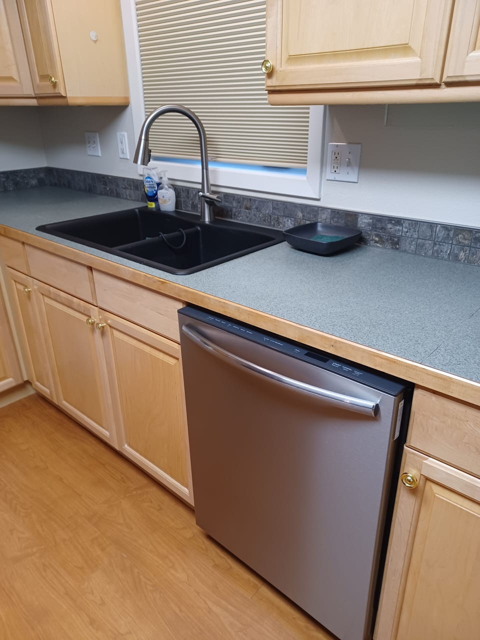 Kitchen with dishwasher and detergents. Ample counter tops and appliances
