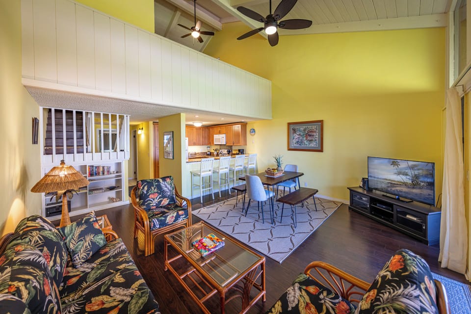 Spacious open-concept living and dining area with vaulted ceilings, ceiling fan,