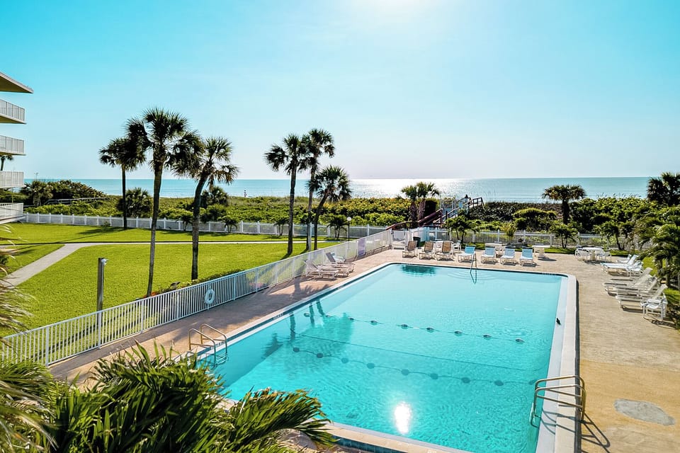 Sparkling heated pool surrounded by swaying palm trees and lush greenery