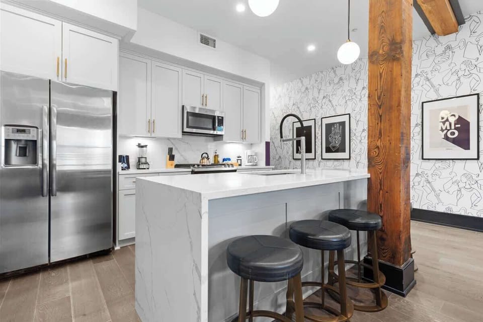 Cook or snack in style with a full kitchen featuring GE stainless appliances, cookware, and an island with bar seating. Ideal for short or extended stays, our kitchens make group travel in New Orleans easy and comfortable.