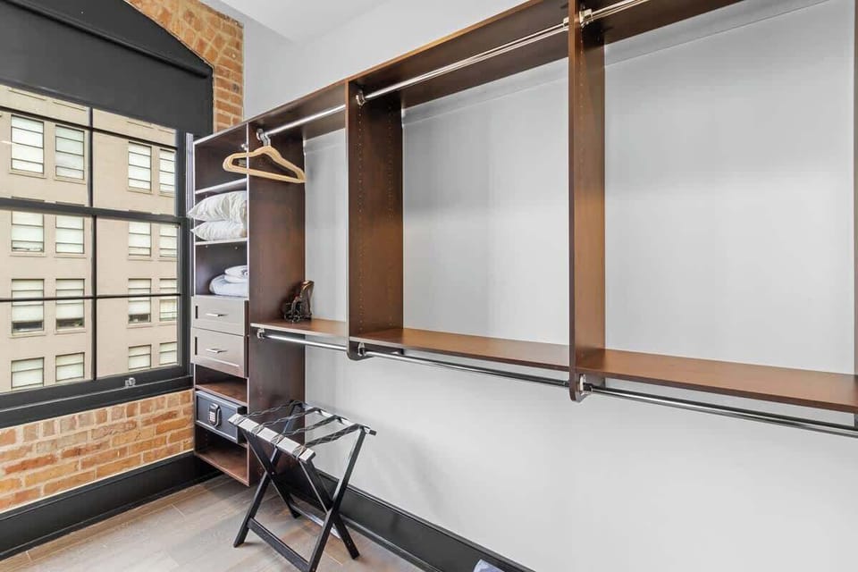 The primary bathroom offers sleek finishes, a soaking tub with Smart TV, walk-in shower, and plush towels. Spacious and private, it adds a luxurious touch to your suite—perfect for unwinding after a day in Downtown New Orleans.