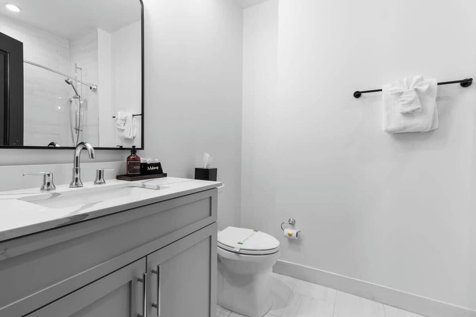 The guest bathroom includes fresh towels, a hairdryer, and complimentary toiletries. Conveniently located near the living area, it’s stylish and practical—perfect for guests, families, or sharing during group stays at 888 Baronne.