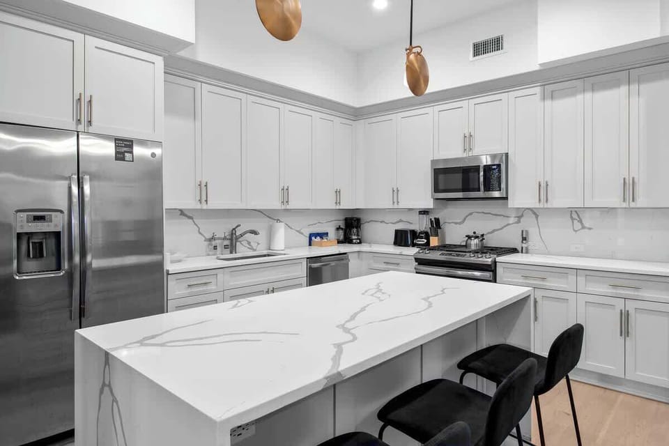 Cook or snack in style with a full kitchen featuring GE stainless appliances, cookware, and an island with bar seating. Ideal for short or extended stays, our kitchens make group travel in New Orleans easy and comfortable.