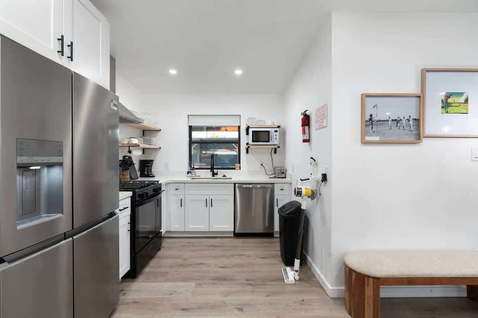 Clean, modern kitchen with stainless appliances and a long counter—pour a drink, prep dinner, and pull up a stool for laid-back kitchen chats.