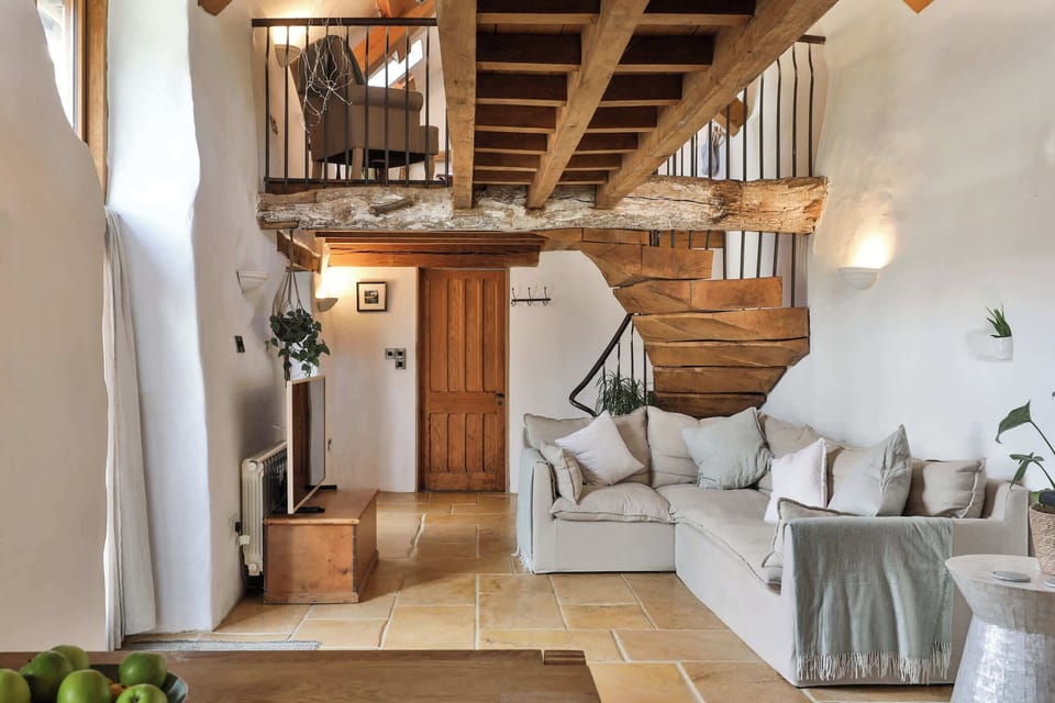 Cosy lounge with plush seating, smart TV, and countryside views – perfect for relaxing after a day exploring the Cotswolds.