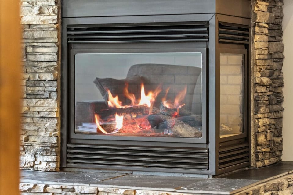 Living room with a gas fireplace, Smart TV with cable & cozy seating with a pull-out couch bed.