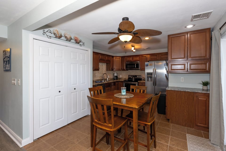 Charming eat-in kitchen featuring modern stainless steel appliances, warm cabinetry, and a cozy dining area.