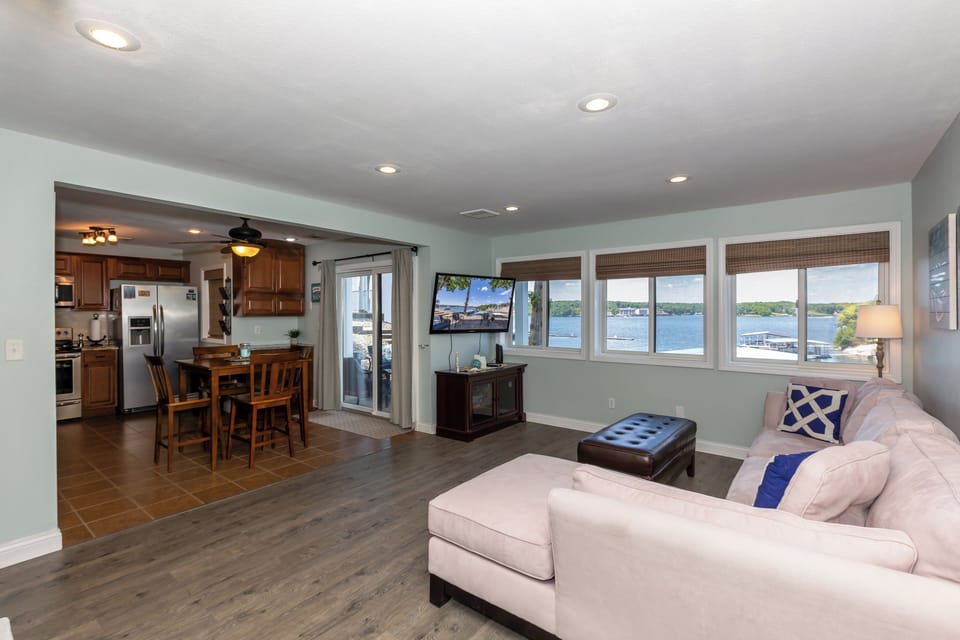This open-concept living space offers beautiful lake views and a cozy ambiance, connecting a modern kitchen and spacious seating area for your perfect vacation retreat.