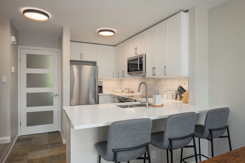 Kitchen with breakfast bar with door leading to the main entryway