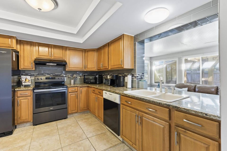 Stunning open-concept kitchen with sleek appliances, overlooking spacious living and dining areas. Perfect blend of style and functionality!