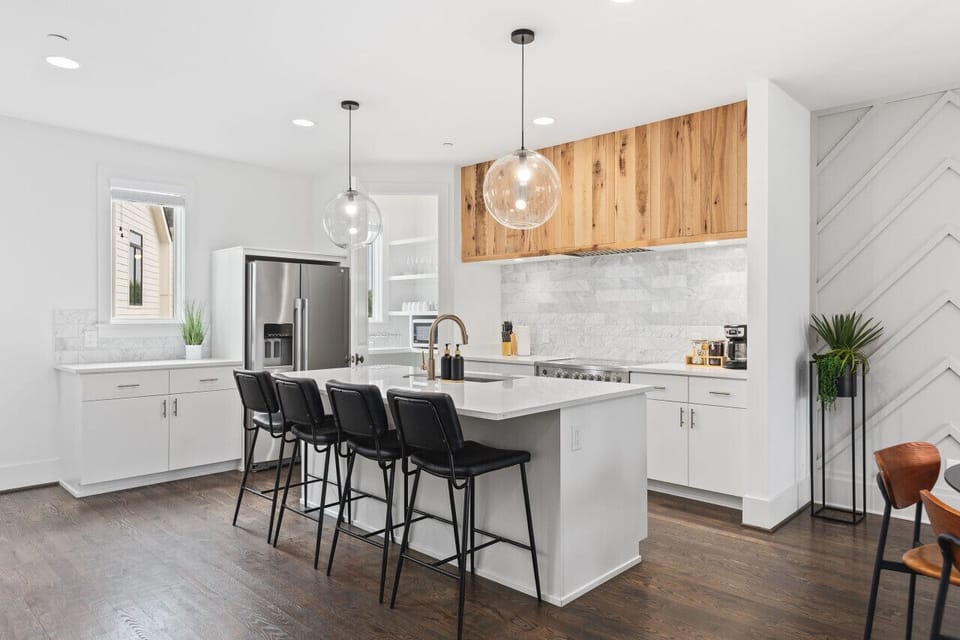 High-end appliances, large pantry, and all the cooking supplies you might need in this bright & fresh kitchen with seating for four at the island.