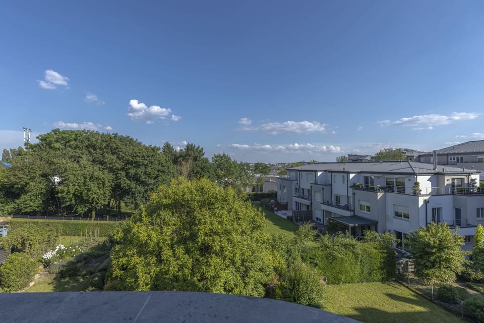 Stunning panoramic views from the balcony, overlooking lush greenery and modern architecture, ideal for unwinding and enjoying the scenery.