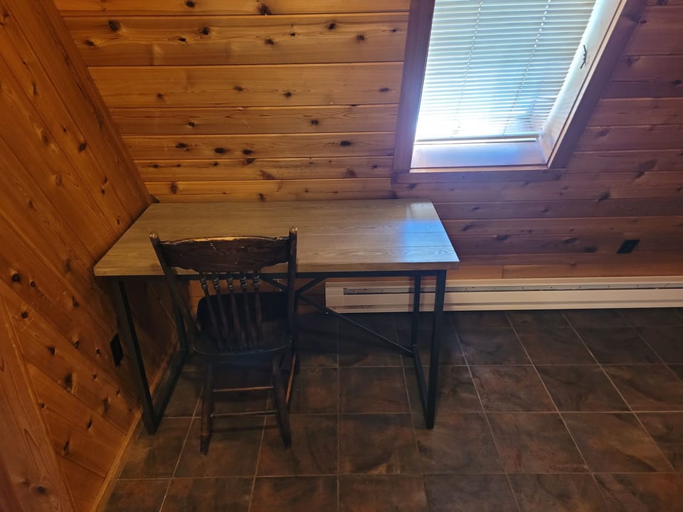 BEDROOM #1 (MAIN FLOOR):  Features a queen-size bed, private en suite bathroom, desk, dresser, mini-fridge, microwave, portable A/C unit, and its own private entrance.