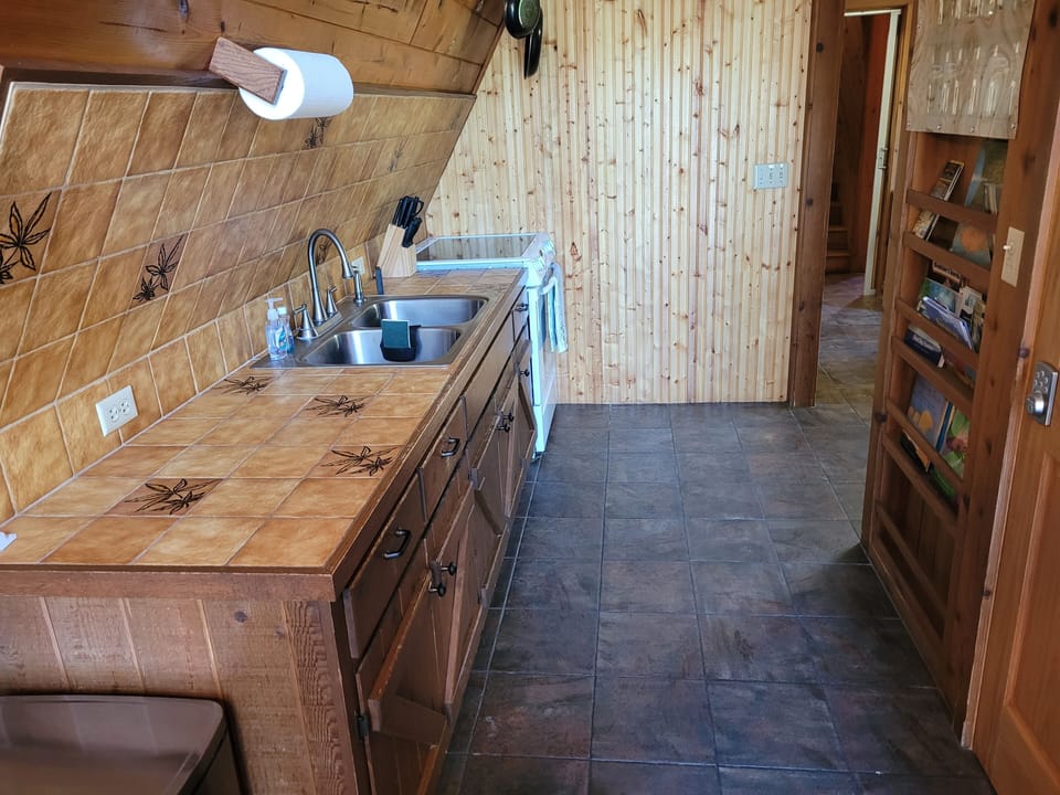 KITCHEN:  Features an electric range, sink, counter space, cabinets, refrigerator, microwave, and coffee maker.  (No dishwasher though.)