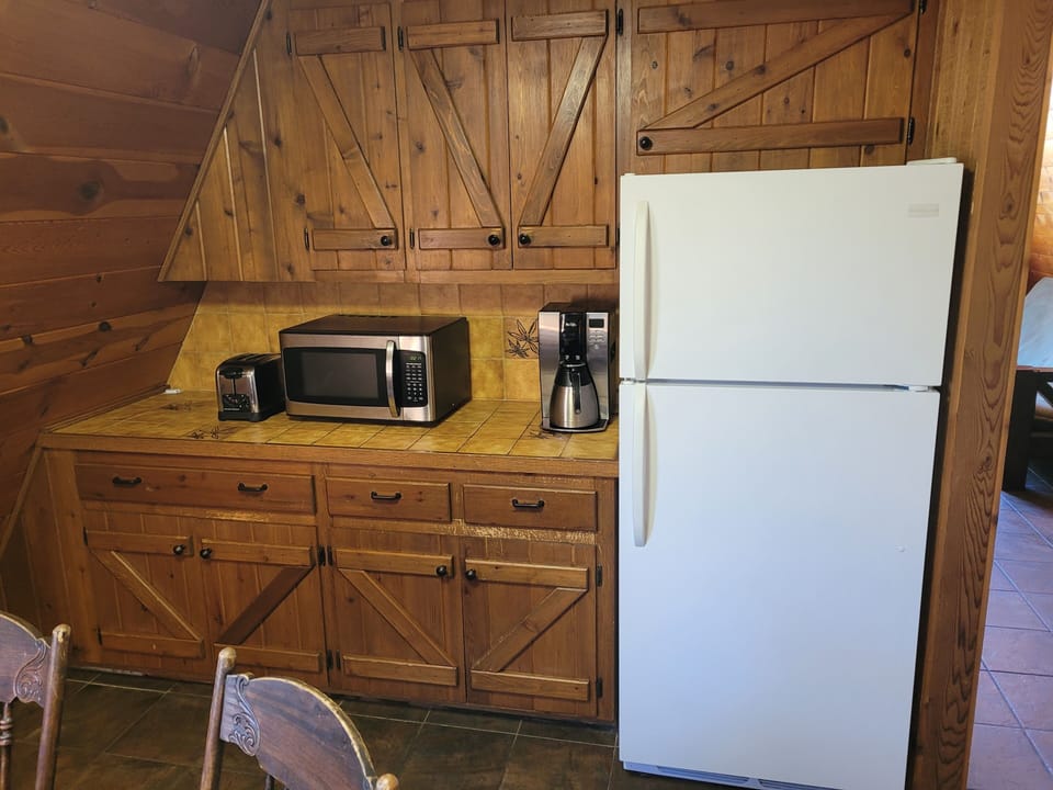 KITCHEN:  Features an electric range, sink, counter space, cabinets, refrigerator, microwave, and coffee maker.  (No dishwasher though.)