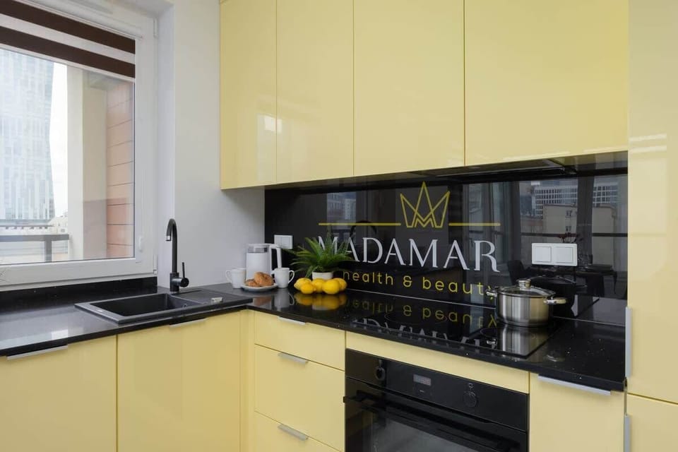 A close-up of a modern kitchen countertop with a stovetop, lemons, and an espresso machine.