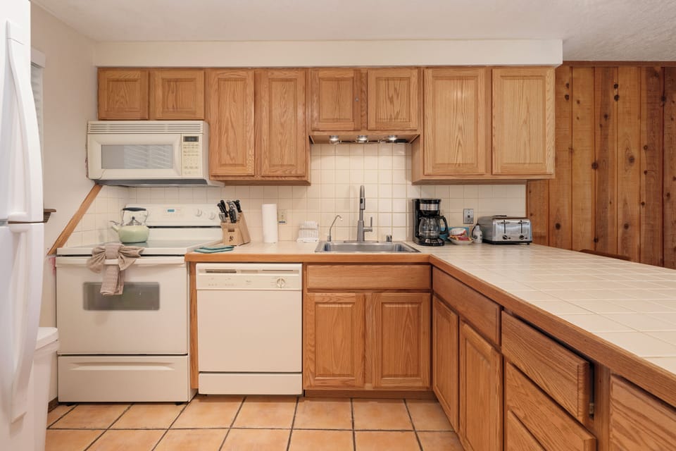 Your fully-equipped kitchen awaits with warm oak cabinets, modern appliances, and ample counter space for preparing memorable meals during your stay.