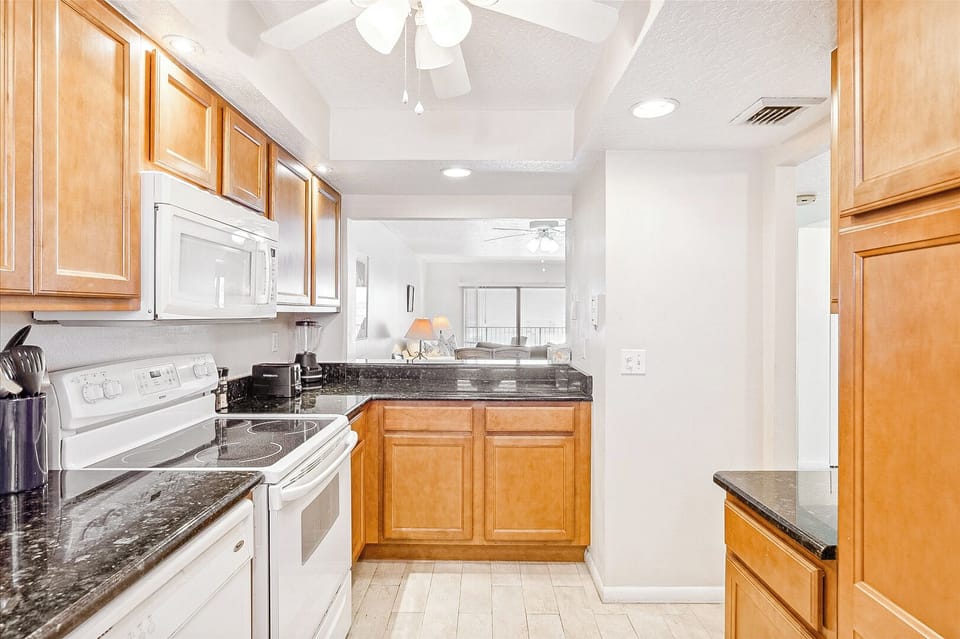 Warm, modern kitchen with wood cabinets, granite countertops, and ample storage space.