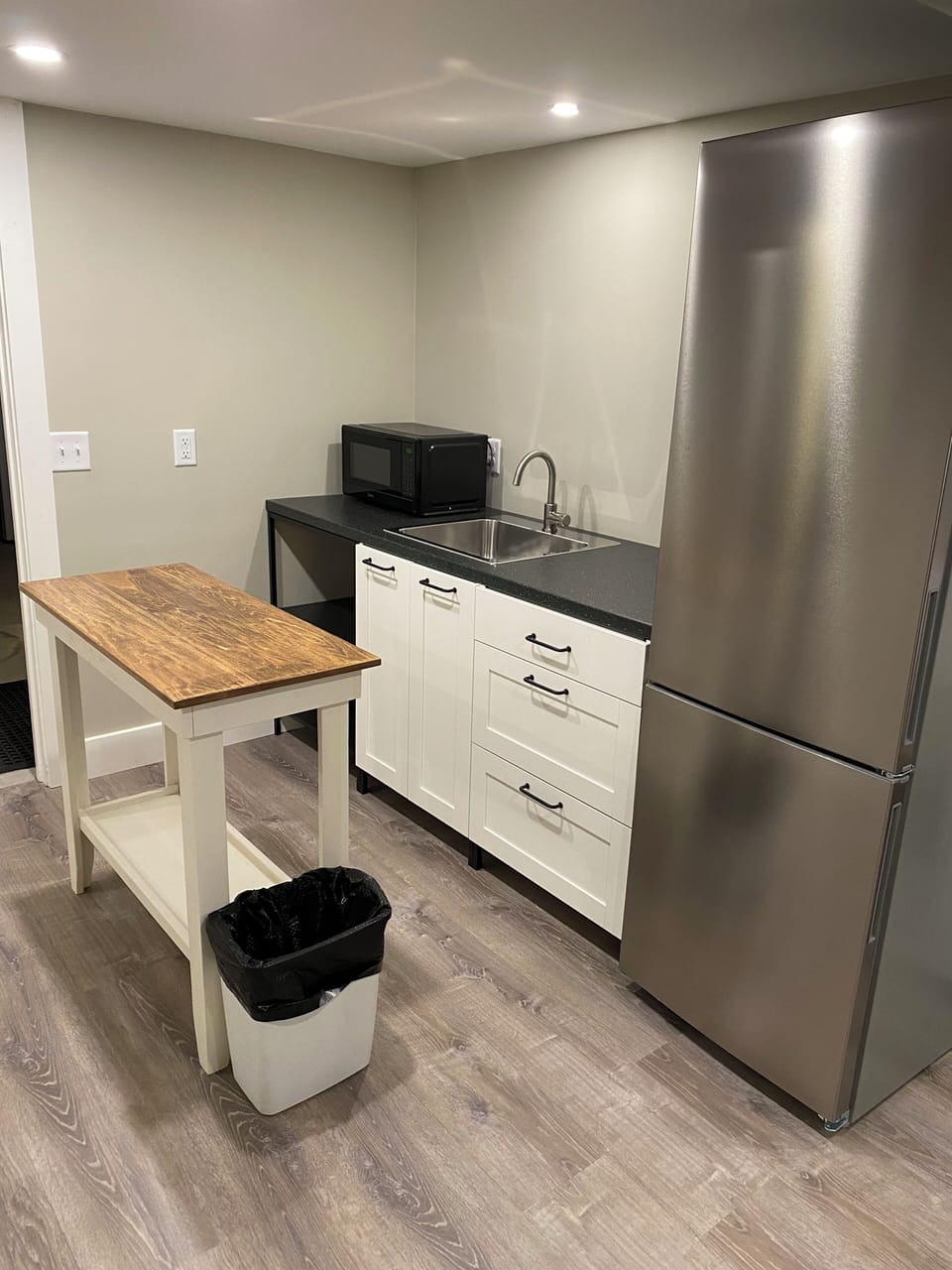 Basement Kitchenette with microwave, fridge/freezer and sink.