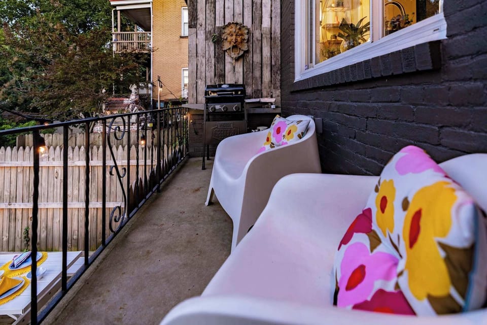 Our charming private balcony for an enchanting urban retreat. Adorned with vibrant, floral-printed chairs and ambient string lights, this space offers a cozy nook for morning coffees or evening barbecues.