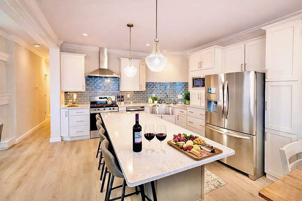 Stunning modern kitchen with a large island, quartz countertops, stainless steel appliances, and stylish pendant lighting—perfect for cooking, entertaining, and gathering with friends.