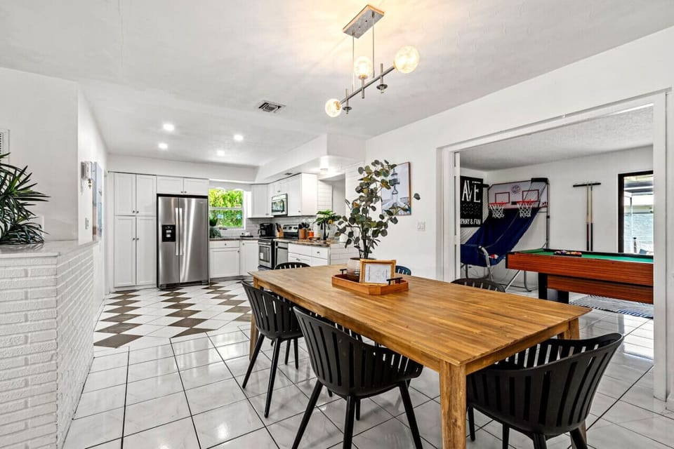 Gather, dine, and make memories in this bright and inviting space! With a modern yet cozy touch, this dining area is perfect for sharing meals and good times with loved ones. Plus, a peek into the game room promises endless fun!