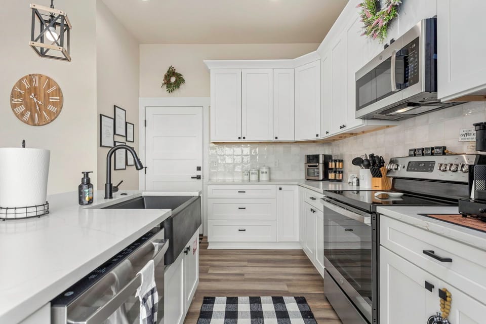 Bright farmhouse kitchen with quartz, coffee bar & stainless suite.