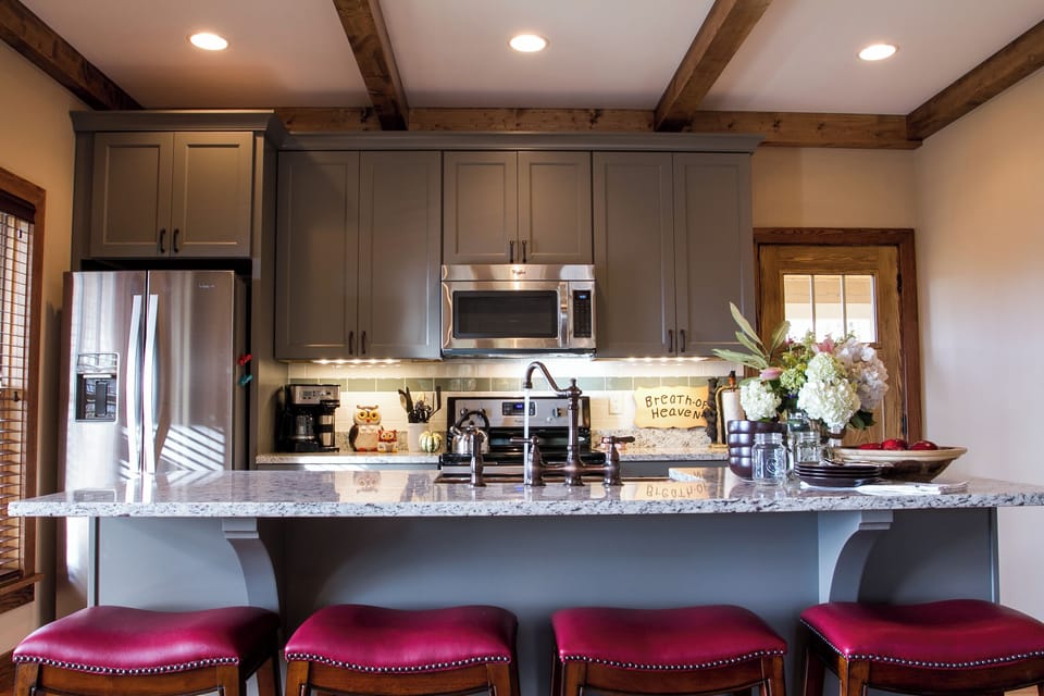 Prepare delicious meals in the modern kitchen, featuring stainless steel appliances and an island with seating for four.