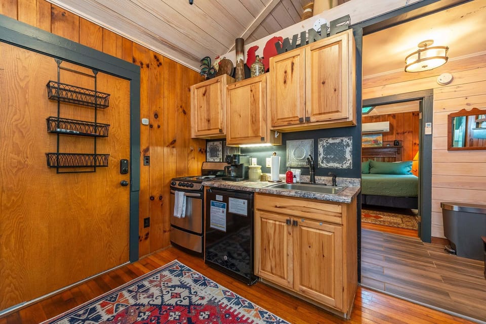 Kitchenette with a small refrigerator, apartment-size stove, and Keurig coffee maker.