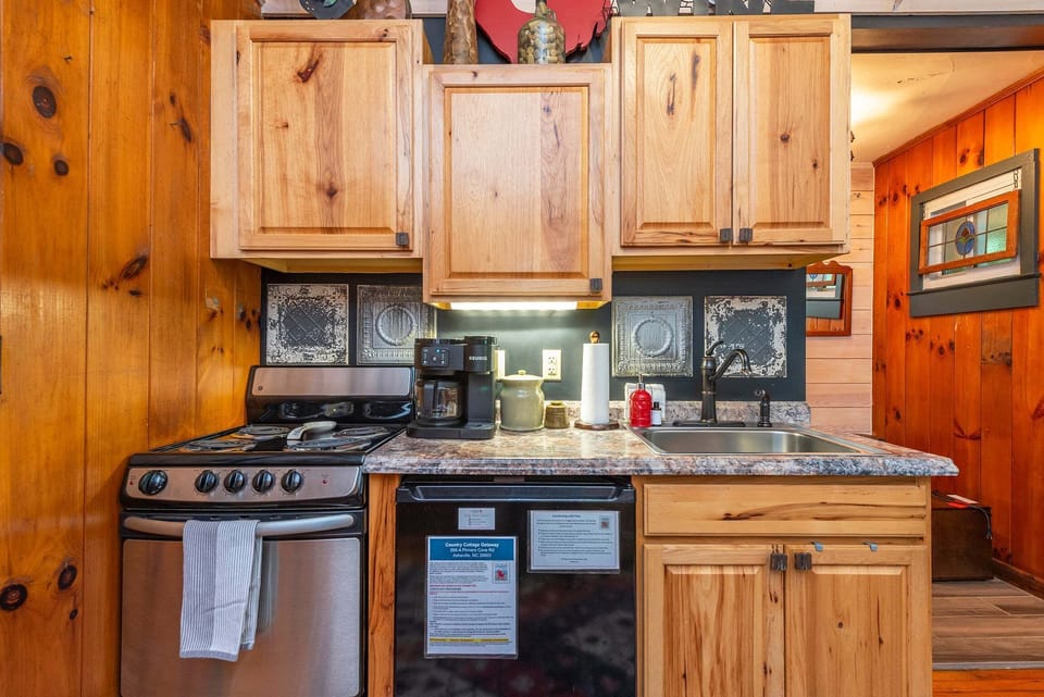 Kitchenette with a small refrigerator, apartment-size stove, and Keurig coffee maker.