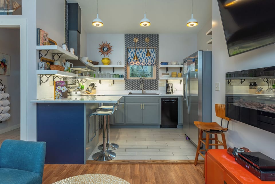Modern kitchen with island seating and stainless appliances.