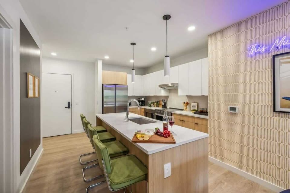 Fully equipped modern kitchen stocked with all culinary essentials and featuring brand new stainless steel appliances with an island offering bar seating.