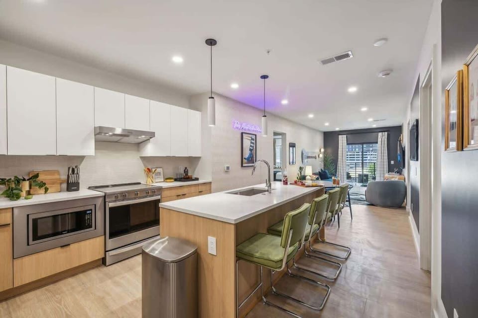 Fully equipped modern kitchen stocked with all culinary essentials and featuring brand new stainless steel appliances with an island offering bar seating.