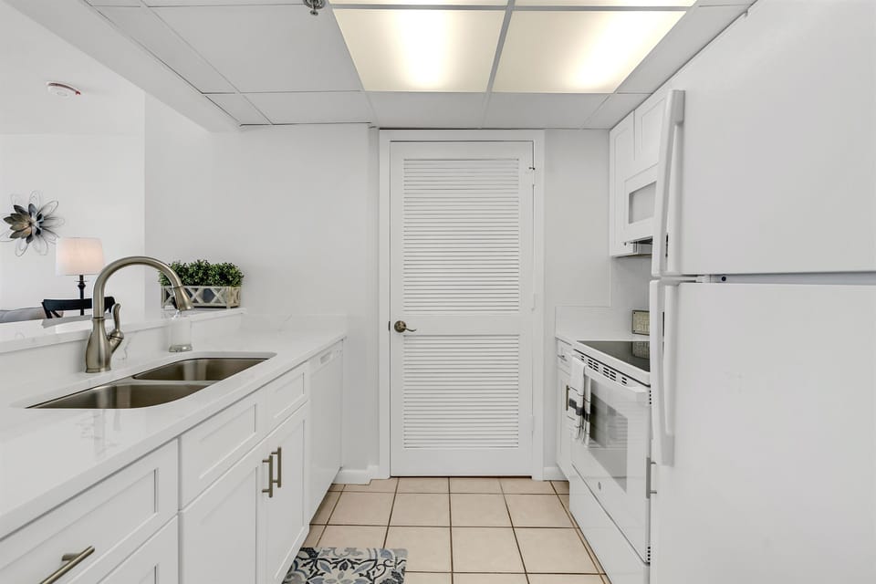 Your pristine galley kitchen features stainless steel appliances and bright white cabinetry, perfect for preparing memorable meals during your stay.