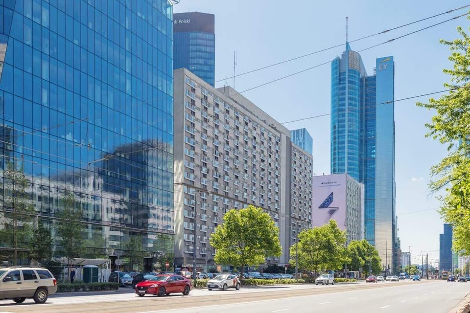 A lower perspective of the glass high-rises in the city with tree shadows in the foreground.