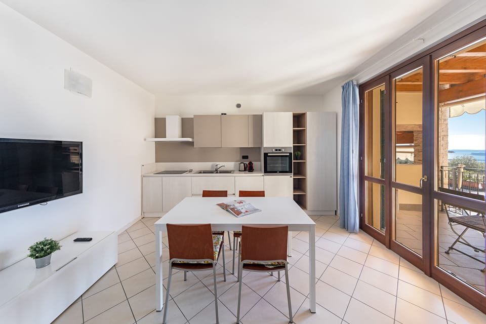 Apartment, Balcony, Partial Lake View | Private kitchen | Fridge, microwave, oven, stovetop