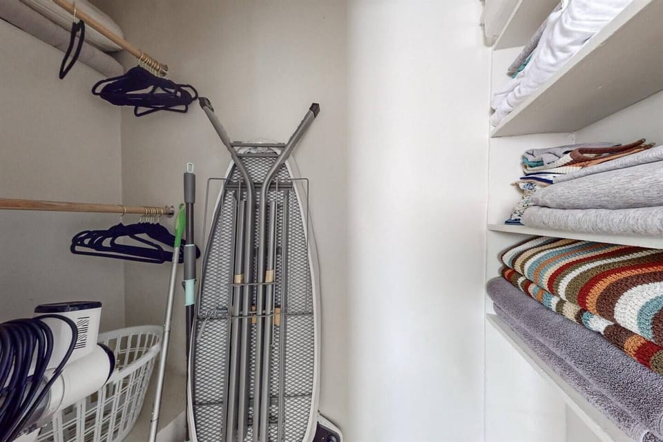 Iron and ironing board in closet in bedroom