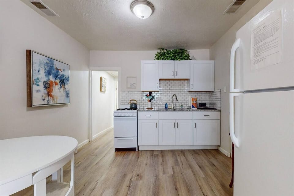Simple kitchen with refrigerator, gas stove, coffee maker, and microwave