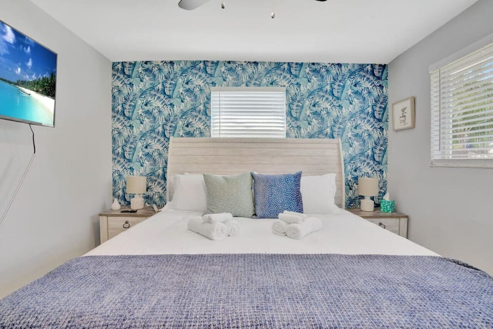 Comfortable bedroom with tropical accent wall