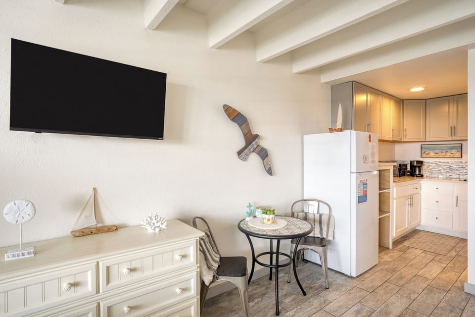 Charming studio with beach-themed decor, cozy bed, and a relaxing sitting area.