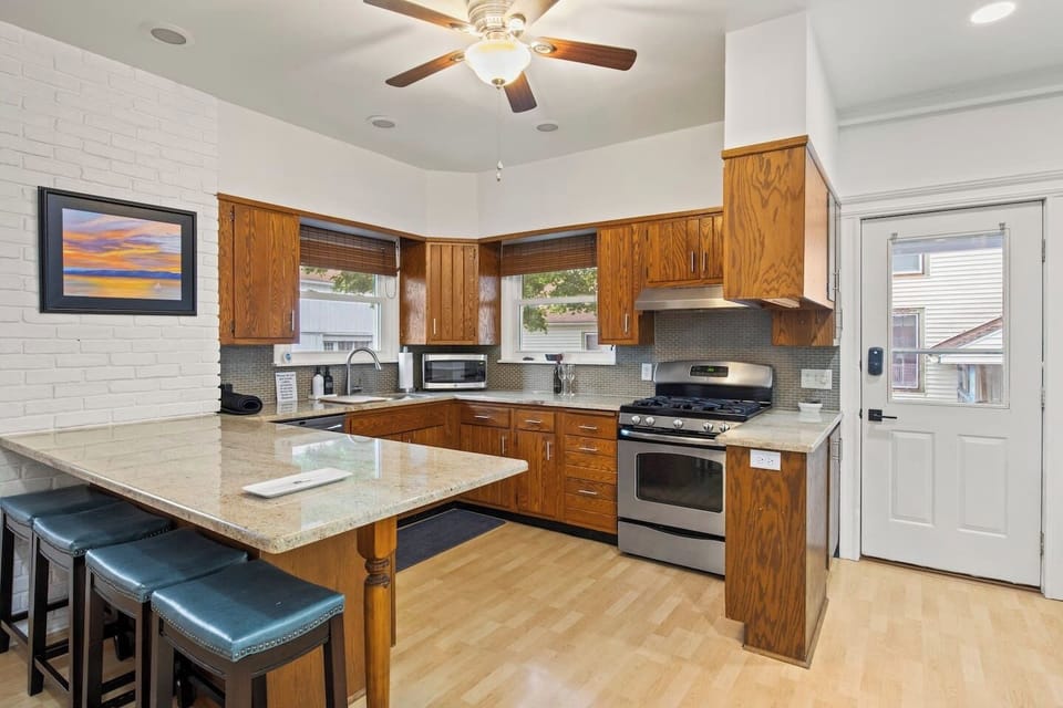 Kitchen - Modern kitchen with stainless steel appliances, granite countertops, and a spacious breakfast bar. Ideal for cooking and casual dining.
