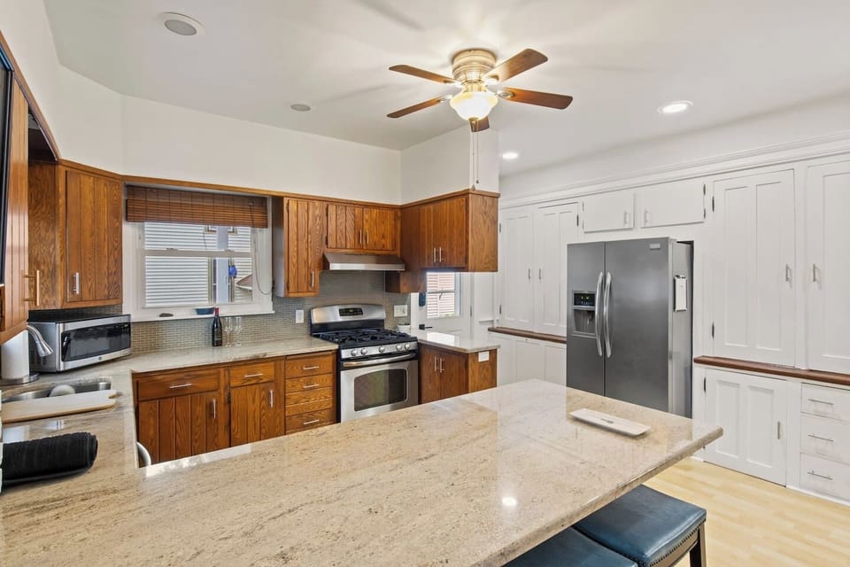 Kitchen -Bright kitchen with stainless steel appliances, ample cabinet space, and a large granite island. Perfect for meal prep and family gatherings.
