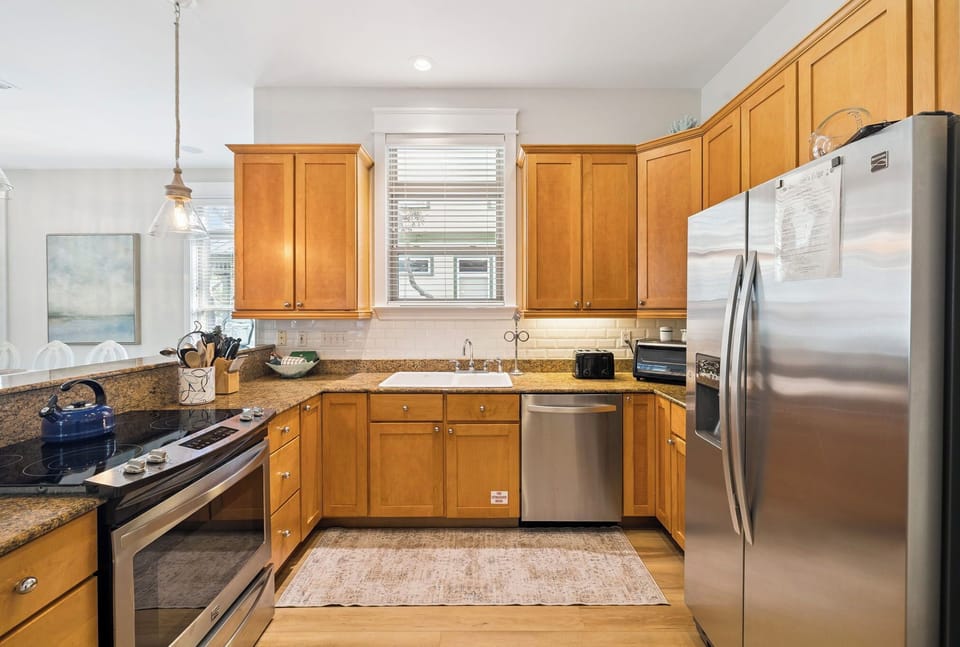Your fully-equipped kitchen features warm wood cabinets, granite counters, and stainless steel appliances—perfect for preparing meals during your stay.