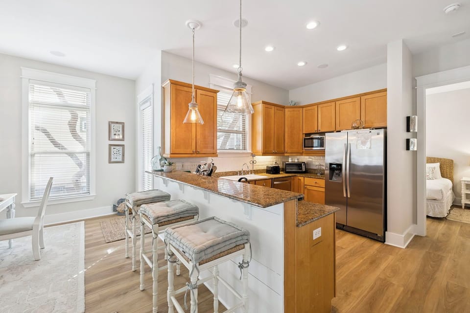 Your fully-equipped kitchen features granite countertops, stainless steel appliances, and a breakfast bar perfect for morning coffee or casual meals.