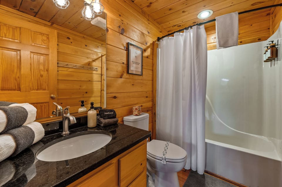 Step into relaxation with our bathroom featuring a combination tub and shower, complete with soft towels for a cozy experience.